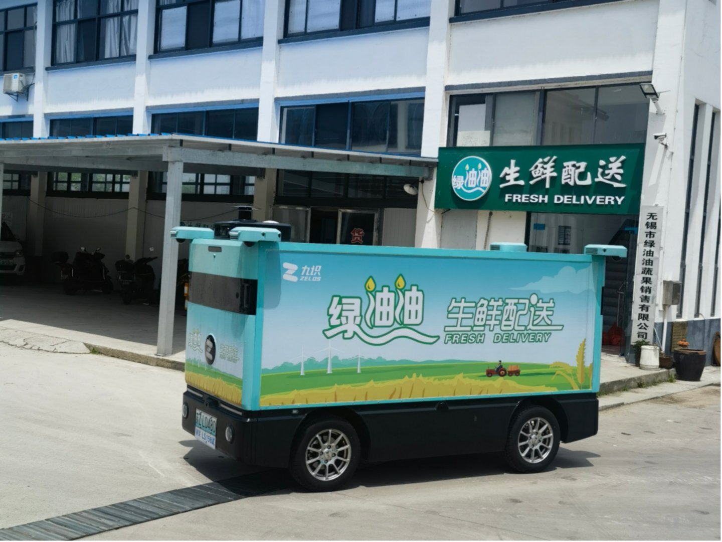 上图： 在无锡，九识智能车每天凌晨四点从蔬菜批发市场装满生鲜果蔬后，自动行驶回分拣中心，再由这里自动行驶至市区、乡镇各单位食堂运送食材，有效降低了食材生鲜行业的运输配送成本，减少了食材的运输损耗，也实现了人力资源的合理配置。